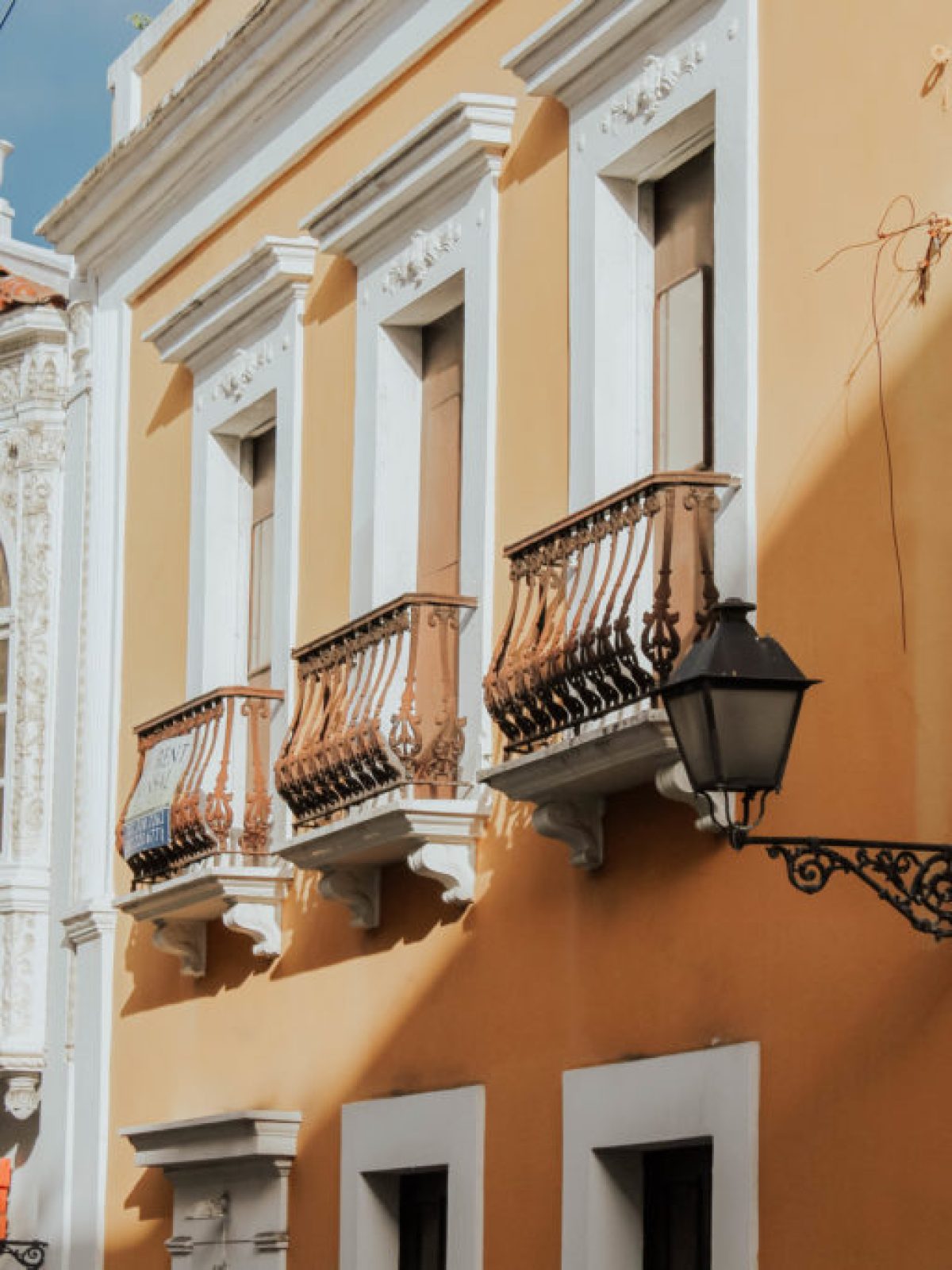 Colorful colonial-style buildings with balconies and ornate details under a clear sky.