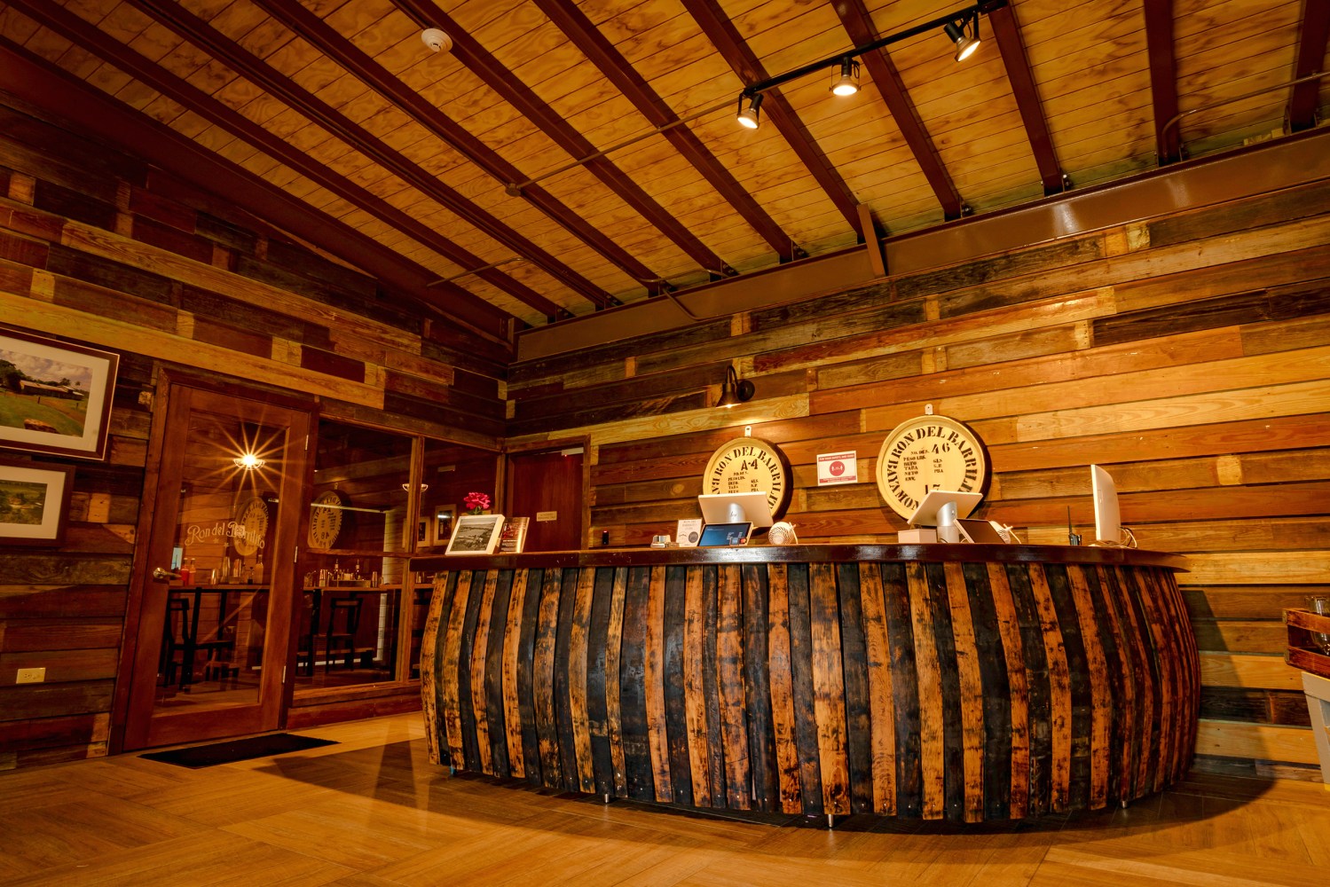 Wood-paneled room with curved reception desk and decorative wall clocks.